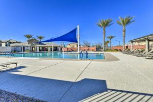 吉尔伯特Spacious Gilbert Vacation Rental with Patio!的一个带蓝色帐篷和棕榈树的游泳池
