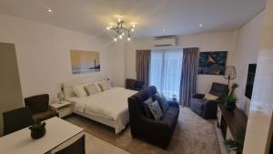 BawaleshiThe Signature Luxury suites CPG的一间卧室配有一张床、两把椅子和一张桌子