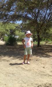 卡诺阿斯德蓬萨尔Camping Matufa Mancora的站在田野上戴帽子的小女孩