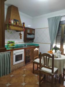 安特克拉CASA RURAL EL CHAPARRO的厨房配有桌子、水槽和桌椅