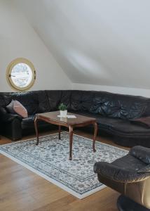 Šentjošt nad HorjulomApartments Možinetova hiša的客厅配有黑色沙发和咖啡桌