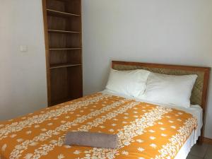 MaateaPension Te Aroha - Te Rai的一间卧室配有一张带枕头和书架的床