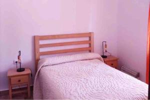 Ojuelos AltosCASA RURAL LOS ALTOS的一间卧室配有一张床、两个床头柜和两盏灯。