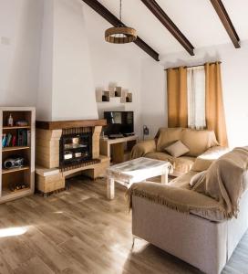 Ojuelos AltosCASA RURAL LOS ALTOS的带沙发和壁炉的客厅