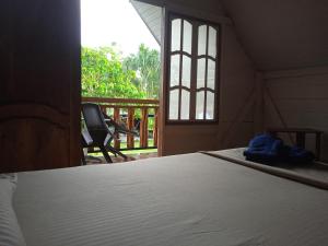 莱蒂西亚Hotel Karupa Amazonas的一间卧室设有一张床和一个带窗户的门廊