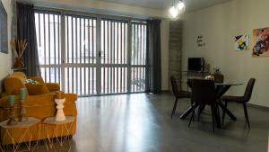 卡塔尼亚Etna Suite Design Apartments的带沙发和桌子的客厅以及用餐室