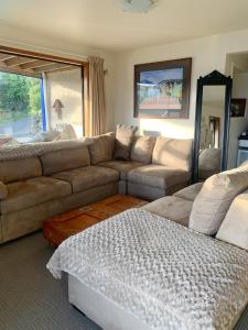 但尼丁Otago Peninsula Paradise的客厅配有沙发和桌子
