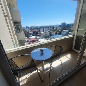 奥索尔诺Departamento Centro Osorno的阳台设有一张桌子和两把椅子,并设有一个窗户