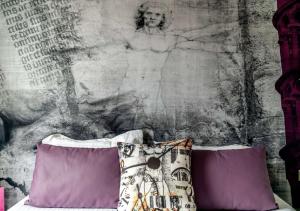 阿姆博斯贝斯特韦斯特芬奇卢尔瓦雷酒店的一张带紫色枕头的床和一幅画墙