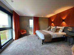 昂泽圣奥宾Best Western Plus Le Fairway Hotel & Spa Golf d'Arras的一间卧室设有一张大床和一个大窗户