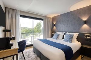 昂泽圣奥宾Best Western Plus Le Fairway Hotel & Spa Golf d'Arras的酒店客房设有一张床和一个大窗户