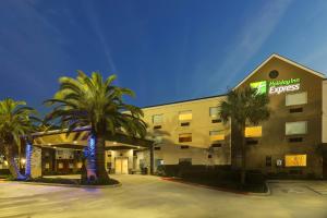 肯纳Holiday Inn Express Kenner - New Orleans Airport, an IHG Hotel的一座酒店大楼前面有棕榈树