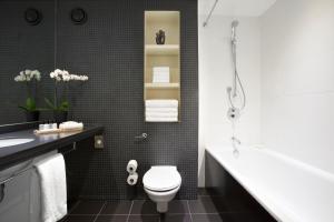 伦敦皇冠假日伦敦多克兰酒店的浴室配有卫生间、盥洗盆和浴缸。