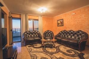 多布拉沃达爱慕别墅公寓式酒店的客厅配有两张真皮沙发和一张桌子