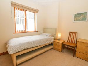 瓦利Arwelfa的卧室配有床、椅子和窗户。