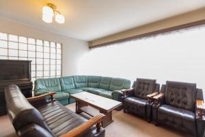 Sakurajima樱岛海滨酒店的客厅配有真皮沙发和电视