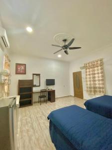 珍南海滩Cenang Room Rahsia Motel的一间卧室配有蓝色的床和吊扇