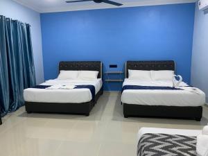瓜埠VILLA TASIK TONGKANG KELI LANGKAWI的蓝色墙壁客房的两张床