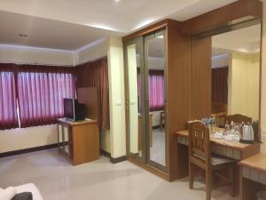 奥南海滩Baan Thara Guesthouse的酒店客房配有电视、桌子和椅子