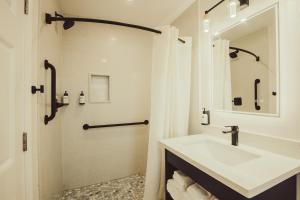 莫罗贝Blufftop Inn & Suites - Wharf/Restaurant District的白色的浴室设有水槽和淋浴。