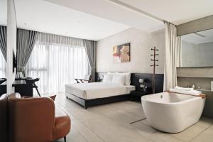 胡志明市Triple E Hotel Metro Ben Thanh的酒店客房配有一张床和浴缸。