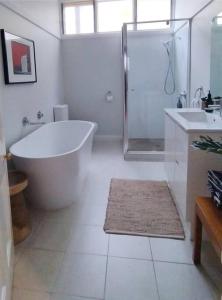 本迪戈Heritage Cottage in the heart of Bendigo的带浴缸、淋浴和盥洗盆的浴室