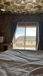 阿尔哈姆拉jabal shams view stay نزل إطلالة جبل شمس的一间卧室设有一张床和一个大窗户