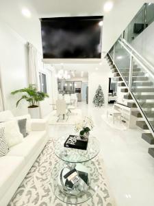 马尔斯港Moss Manor的客厅配有白色沙发和玻璃桌