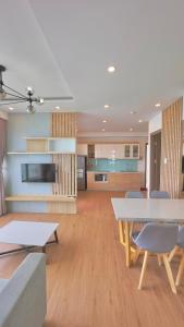 芽庄Oceanus Oasis Retreat Muong Thanh Vien Trieu的厨房以及带桌椅的起居室。