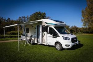 SchellePop Up Camping Tomorrow's Paradise的一辆白色卡车停在野营车的田野里