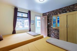 吉婆岛Victor Charlie Hostel的一间卧室设有两张床和窗户。