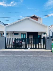 阿罗士打Homestay Alor Setar Nearby Hospital Sultanah Bahiyah的白色的房子,有门和栅栏