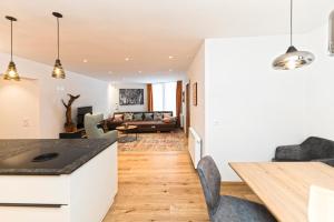 萨姆瑙恩Bel`Laret的厨房以及带白色墙壁和木地板的客厅。