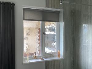 灵伍德Forest Heath Holidays - Denphyl的浴室的窗户,带窗帘