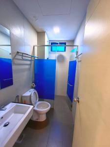 马六甲Lovely Chicks Homestay 5 -10pax 小转鸡主题民宿Atlantis Residence Melaka的一间带卫生间、水槽和蓝色门的浴室