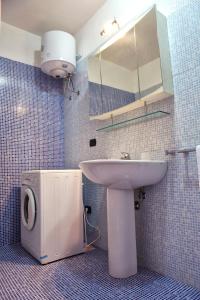 莱乌卡Appartamenti Marinelli - Santa Maria di Leuca的一间带水槽、卫生间和镜子的浴室