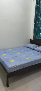 巴力文打Kerian Putra Muslimstay的一张带蓝色棉被和黄色标签的床
