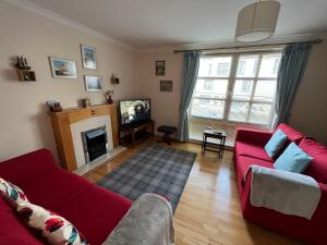 爱丁堡Old town, free parking, Outlander experience的客厅设有红色的沙发和壁炉