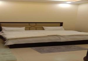 阿格拉Mayur Palace By WB Inn的卧室配有一张带白色床单和枕头的大床。