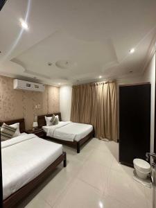 达曼الجناح الأبيض للأجنحه الفندقية的酒店客房设有两张床和窗户。