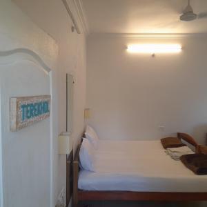 莫尔吉姆Morjim BaywoodGoa Longstays的一间小卧室,配有白色的床和一盏灯
