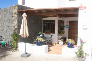 亚伊萨Villa Panoramica的庭院配有遮阳伞和桌椅。