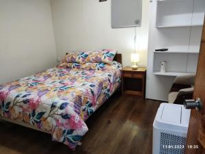 延基韦Hospedaje Lago Llanquihue的小卧室配有一张带色彩缤纷的被子的床