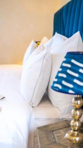 马拉喀什Riad villa saphir & SPA的白色的床、白色枕头和蓝色毯子
