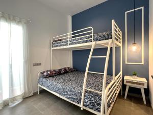 瓦伦西亚Maritime Apartamentos Valencia的一间卧室设有两张双层床和蓝色的墙壁