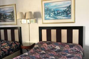 罗克福德Travelodge by Wyndham Rockford South的卧室配有两张床,墙上挂有两张照片