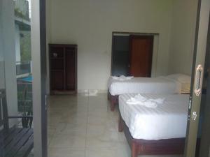姆杜克阿迪拉沃恩民宿的客房设有两张床和一个阳台。