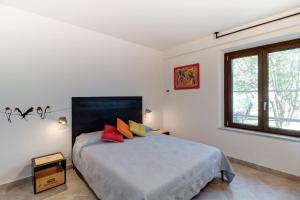 马利亚诺因托斯卡纳Artemisia negli ulivi b&b的一间卧室配有红色和黄色枕头的床