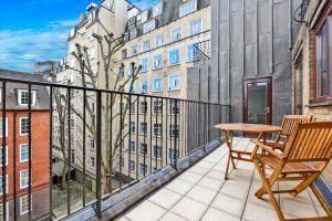 伦敦Tavistock Place Apartments的阳台配有木桌和木椅。