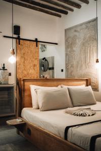 帕杰BaraBara Eat&Sleep - Eco Boutique Hotel的一间卧室配有一张大床和木制床头板